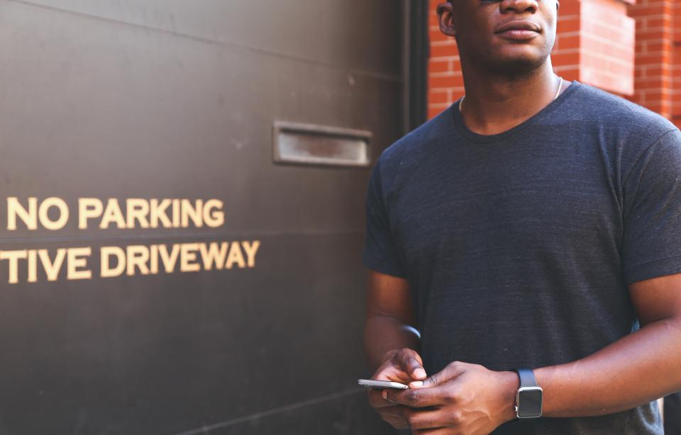 guy, man, people, african american, hands, texting, smartphone, cell phone, mobile, apple watch, no parking, garage, city, bricks, urban