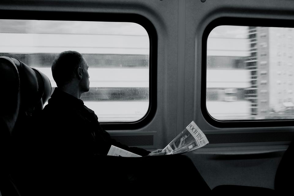 train, railway, transportation, travel, trip, black and white, people, man, sad, reading, newspaper