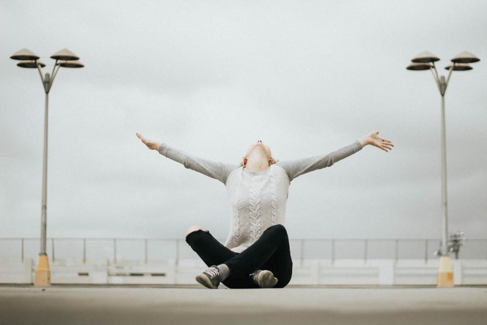 people woman sweater sitting alone pole lamp outdoor worship 