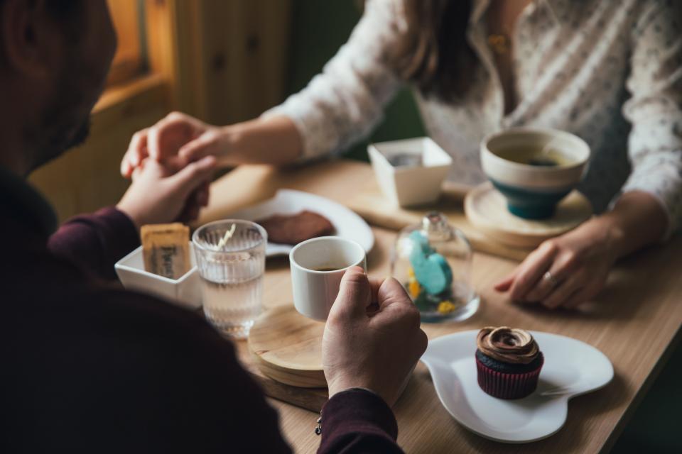 people, man, woman, couple, holding hands, dinner, date, restaurant, coffeehouse, shop, cupcakes, food, eating, desserts, coffee, drink, dining, table