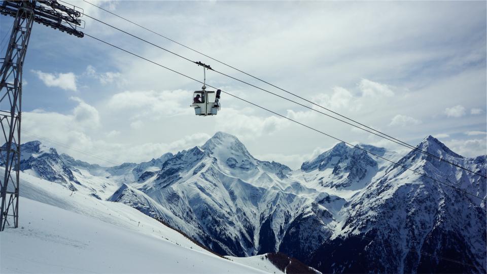 gondola lift snowboarding skiing snow winter mountains peaks sky clouds hill