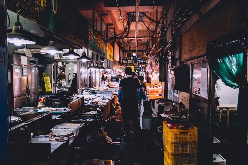 people, men, woman, wet, market, basket, meat, fish, utensil, refrigrator, signage, pail, lamp, light, korea