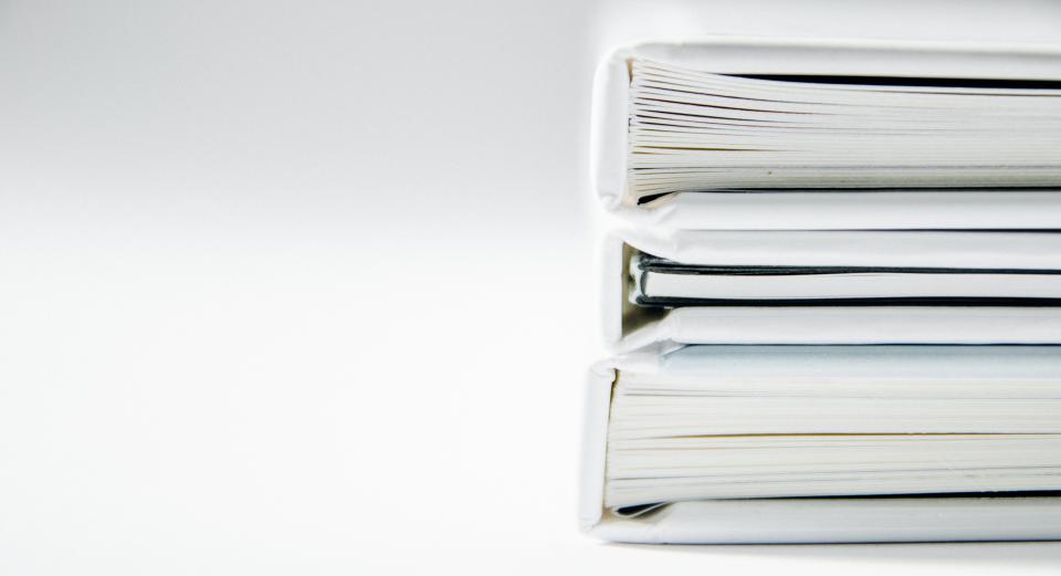 still items things books journals stack pile minimalist white