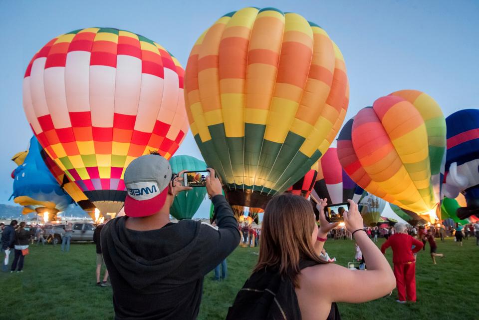 hot air balloon, festival, celebration, colorful, people, crowd, phone, capture, playground, geen, grass, car, vehicle