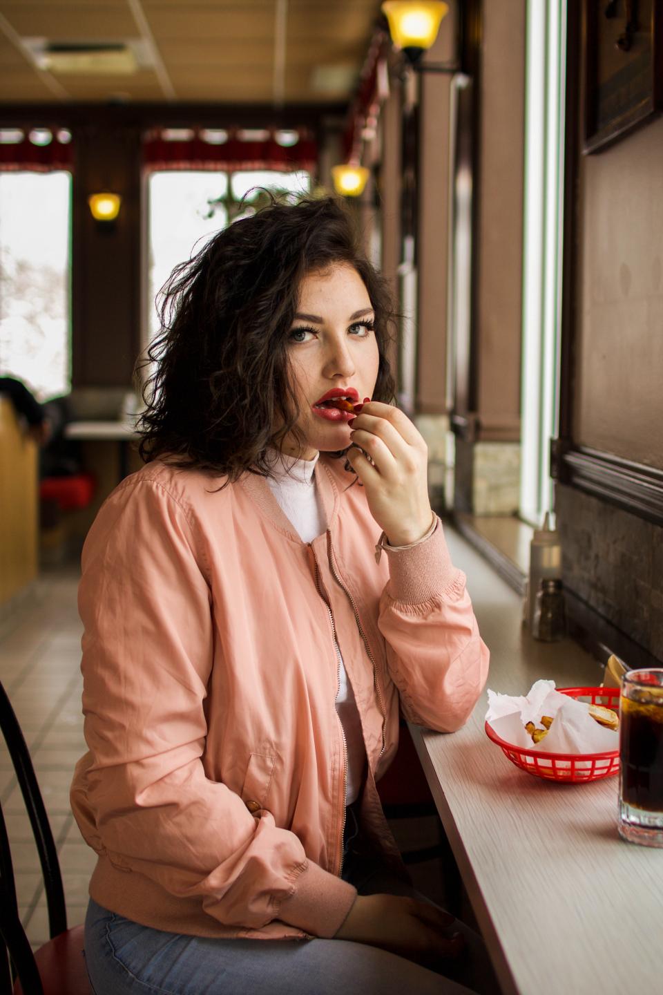 people, girl, woman, sitting, eating, sitting, alone, restaurant, inside