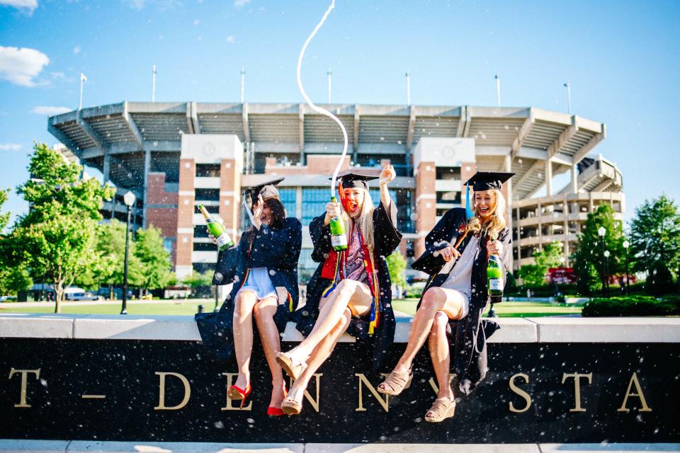 people, women, girls, student, sitting, graduate, school, building, university, graduation, beverage, champagne, sparkling, drink, celebration, blue, sky, field, tree, plant, nature