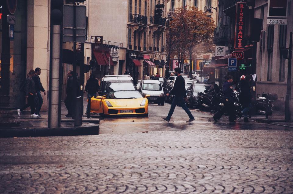 cobblestone streets city urban people walking pedestrian stores shops buildings cars Lamborghini