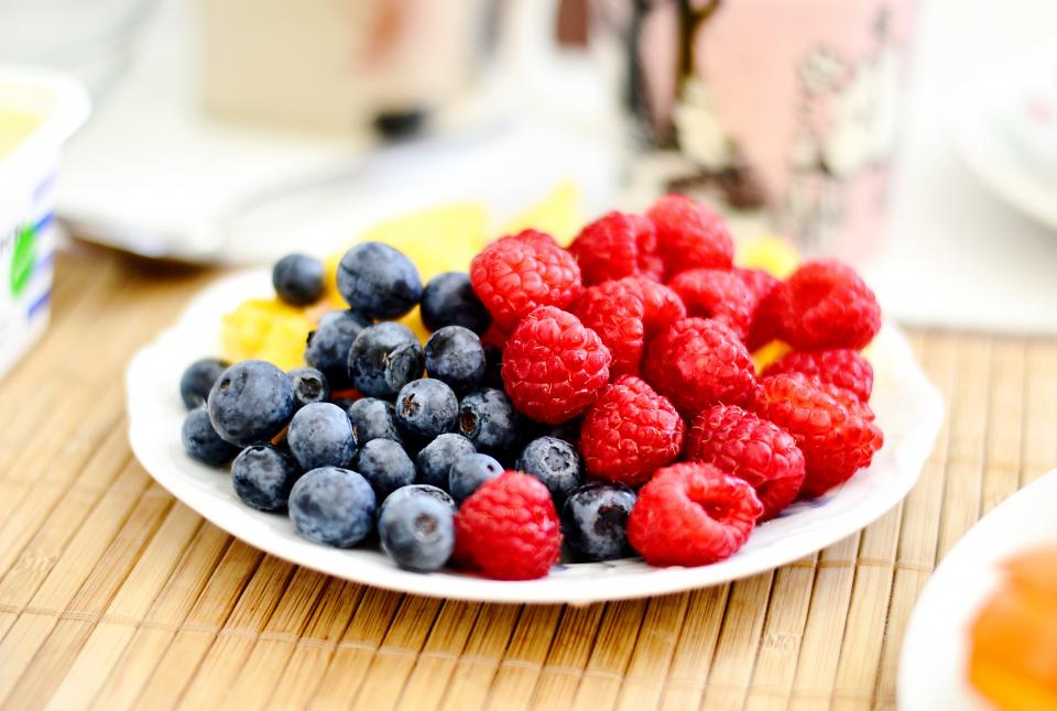 food eat fruits berries raspberries blueberries wood table mat spread plates