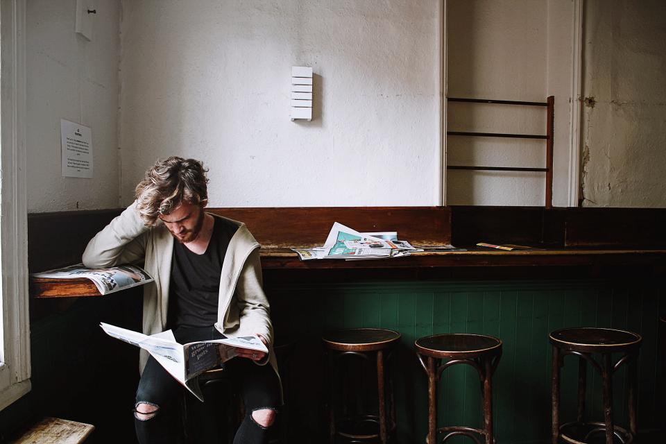 thinking people man reading magazine newspaper alone chair 