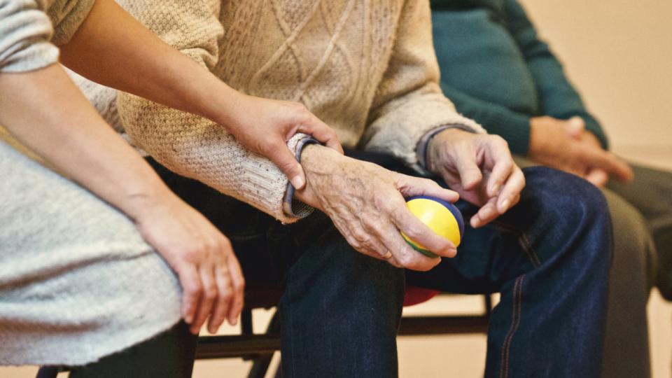 ball people old elderly man sitting woman holding hand arm