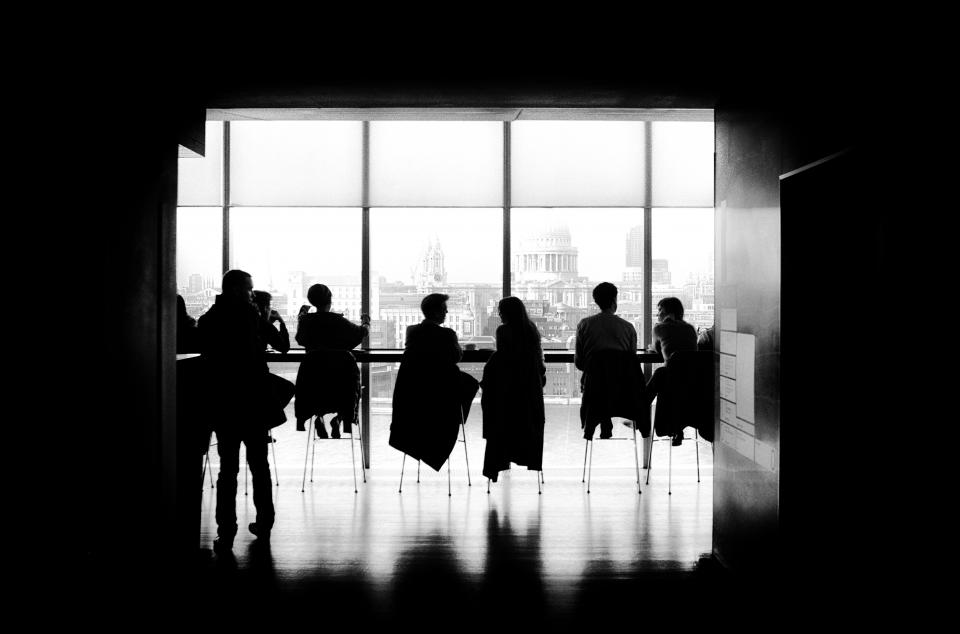 people men girls sitting talking high chairs business black and white building silhouette